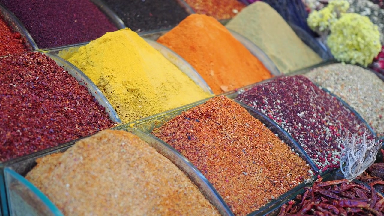 Assorted Colorful Spices Displayed in Glass Containers at Market