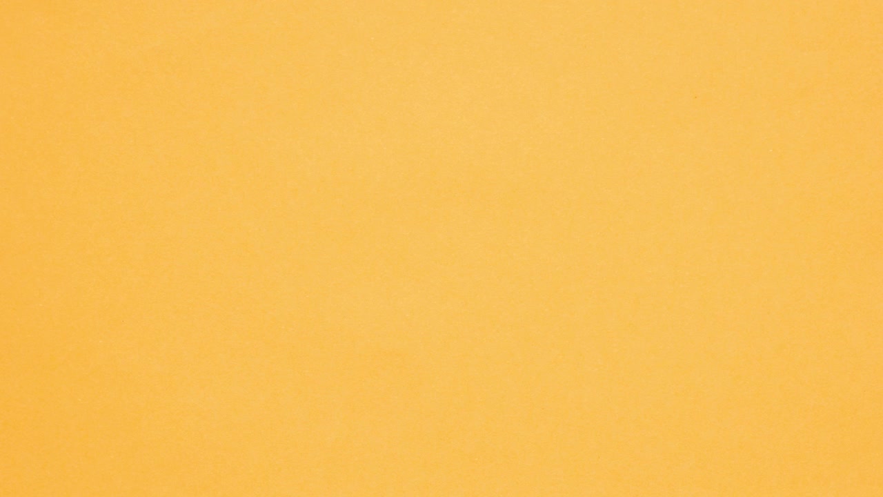 Orange crumpled paper unfolds then refolds on blue in stop motion transition
