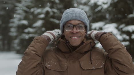 man smiling in snowy forest