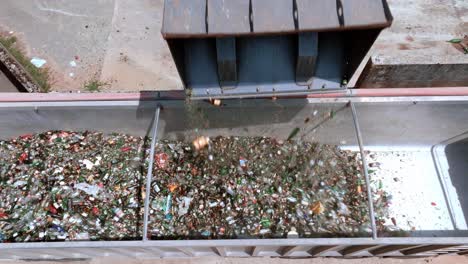 forklift excavator is sipping glass to back of an transporter truck, heavy-duty machine with long arm for a glass-grabbing attachment, drone view, glass recycling in a processing center concept