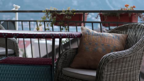 furniture with cross stitch pillow in wicker chair at balcony kotor montenegro