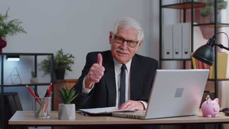 Senior-business-man-raises-thumbs-up,-agrees,-approve,-likes-good-news-using-laptop-at-home-office