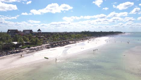 Wide-angle-aerial-drone-view-of-the-busy-sandy-white-beaches-of-the-tropical-island-of-Holbox-in-Mexico-during-a-really-hot-sunny-day-shot-in-4k