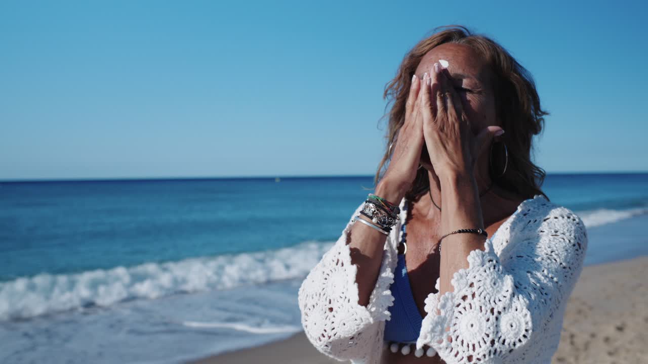 해변 에서 자외선 차단제 를 적용 하는 여자