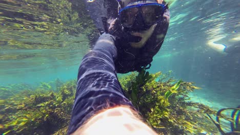 underwater selfie: man snorkelling in shallow clear river current