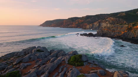 sea beach sunset nature. ocean waves splashing volcanic rocks seashore hills