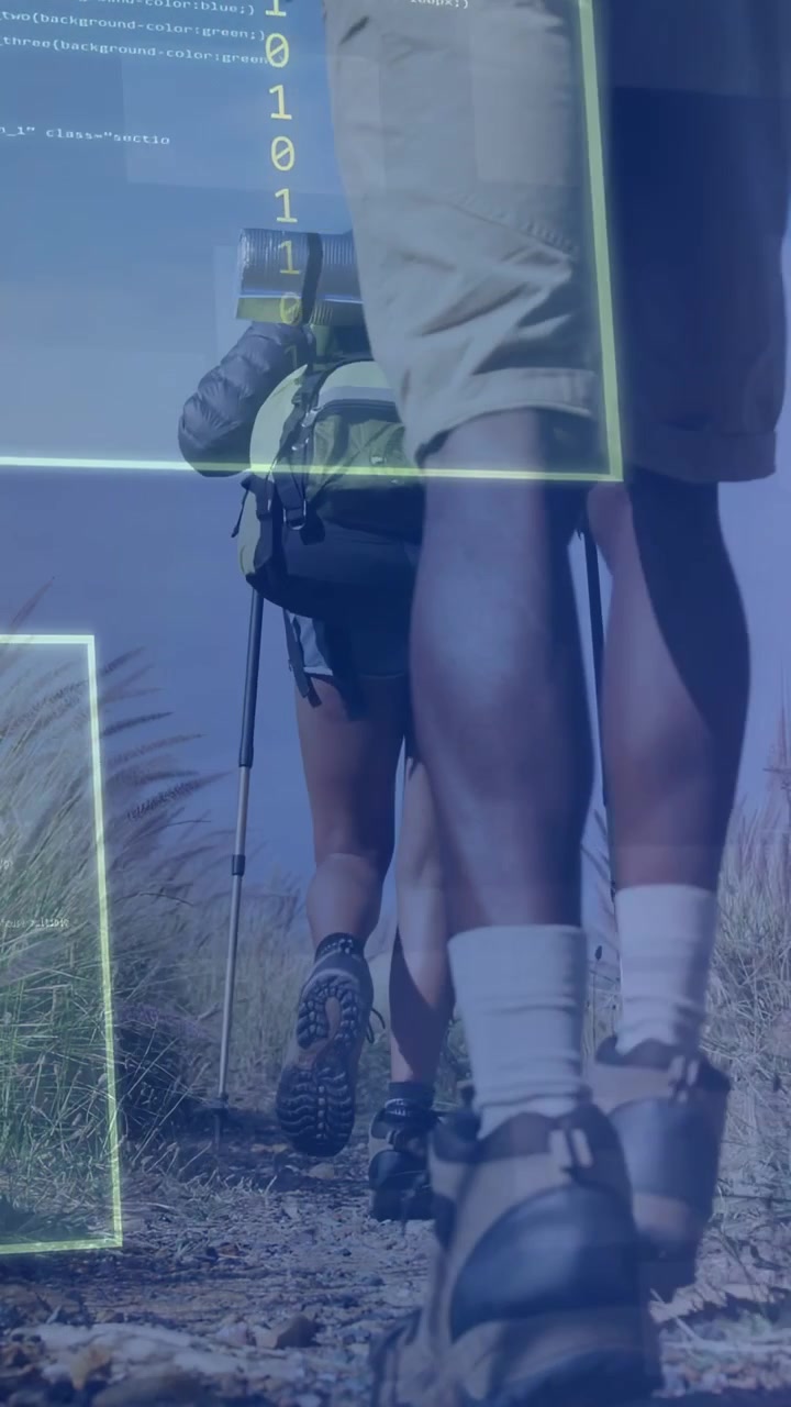 Video verticale: Due escursionisti che camminano sulle dune, i cui passi attivano un HUD che inquadra stivali, bastone e zaini, per la tecnologia di navigazione.