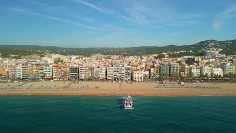 barco de pasajeros, saliendo de la playa de lloret de mar en la costa brava de gerona vistas aéreas frente al ayuntamiento