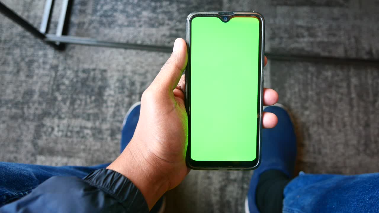 persona que sostiene un teléfono inteligente con pantalla verde