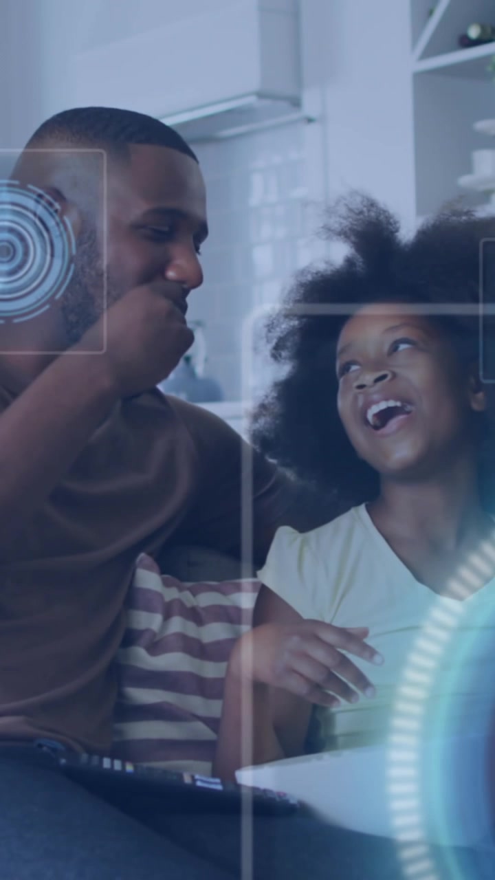 Animation of data processing against african american father and son watching tv at home