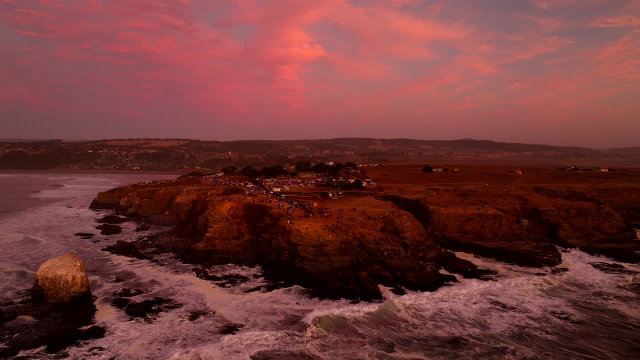 Pacific coast, ocean waves, crimson cliffs, sightseeing tourists, aerial