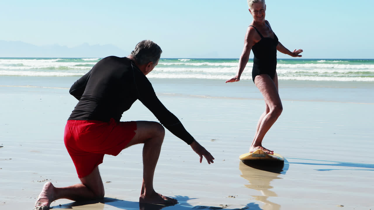 Senior man training woman on beach