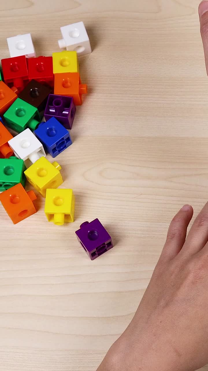 las manos organizan cubos coloridos en una mesa