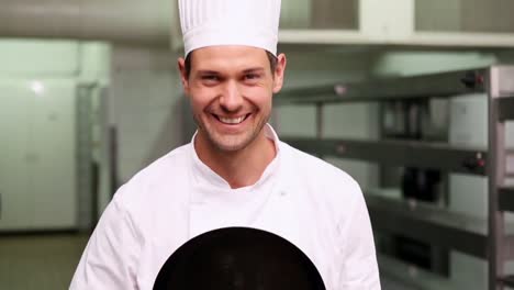 chef changing face behind a frying pan