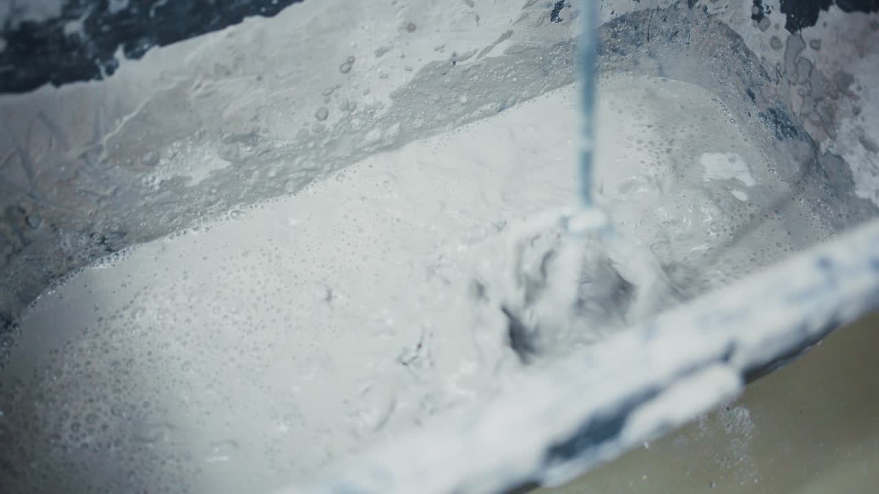 Mixing a Smooth Slurry: The Process of Creating a Homogeneous Mixture in a Construction Bucket for Building Projects