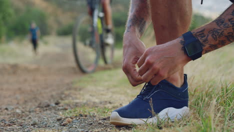 a young man tying his shoelaces while out