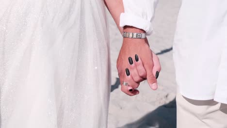 husband and wife hold hands after marriage ceremony