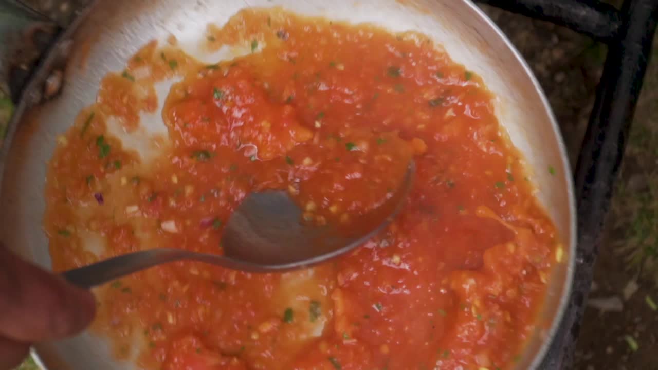 estufa de camping cocinando salsa y revolviendo en sartén 2