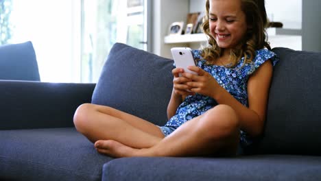 Chica-Usando-Teléfono-Móvil-En-La-Sala-De-Estar