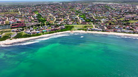 áfrica del sur jbay jeffreys bay avión no tripulado ciudad casa edificios más impresionantes playa de arena blanca épica ola de surf acuático azul escarpado arrecife costa durante el día wsl corona abierto supers boneyard verano pan up