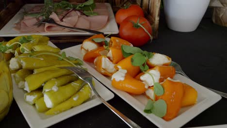 a table with snacks, on which there are plates of stuffed bell peppers