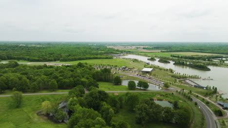 shelby farms park in memphis, showing lush greenery and water bodies, on a cloudy day, wide shot, aerial view