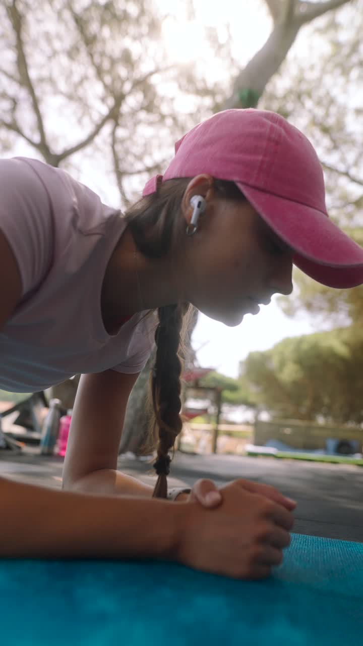 mujer haciendo un ejercicio de tabla al aire libre