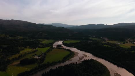 Vista-Aérea-Hacia-Atrás-Sobre-Un-Río,-En-Medio-De-La-Naturaleza-Del-Centro-De-Noruega