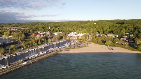 iconic american township with pier and sail boats on sunny day, aerial view