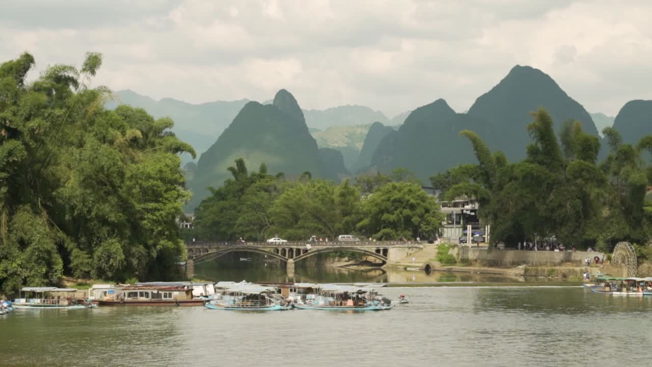 puente sobre el río li con coches, gente y barcos guilin china