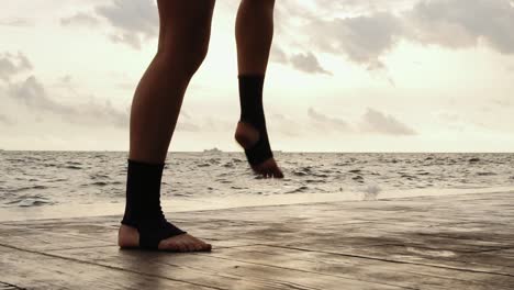 high pace video: female boxer's legs moving on during the training. woman is training by the beach. close up on legs