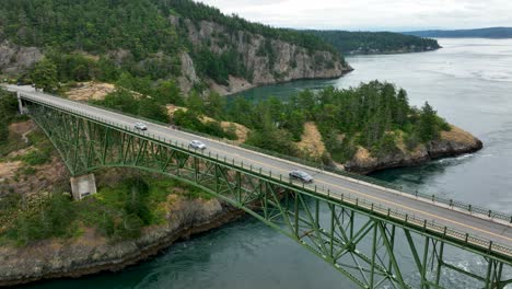 wide static aerial view of cars commuting over the deception pass bridge