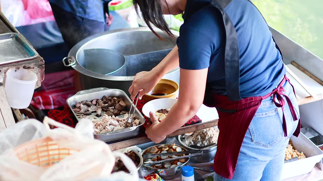 vendedor preparando fideos en el mercado flotante de bangkok