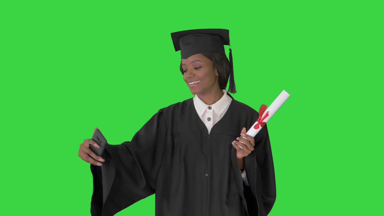 Smiling African American female graduate making selfie with diploma on a Green Screen, Chroma Key