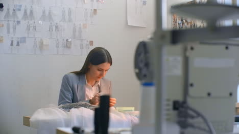 Eine-Junge-Designerin-Fertigt-Im-Atelier-Ein-Kleid-An.-Schneideratelier-Näht-Perlen-Und-Schmuck.-Näherin-Verziert-Ein-Kleid-Im-Atelier.