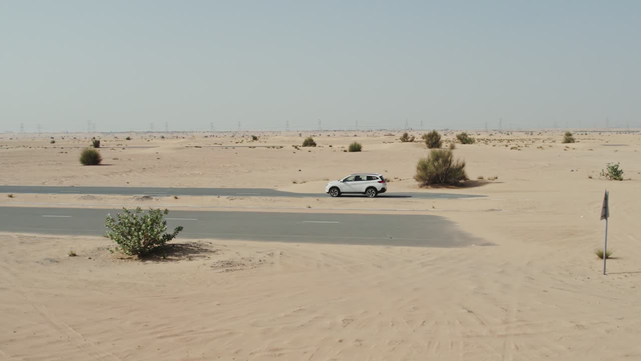 coche blanco conduciendo a través de un paisaje desértico