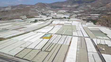 vista aérea de un mar de invernaderos y las áridas montañas de la costa de almería