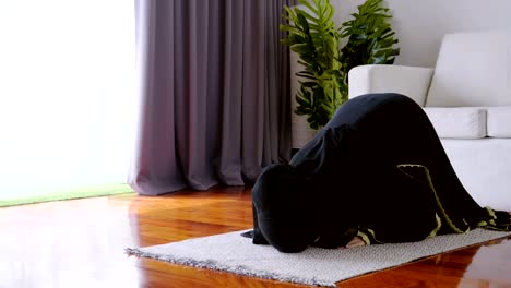 asian young woman muslim prayers bow to pray for blessings in the living room, belief in islam muslims pray at home daily as a blessing for themselves and their family