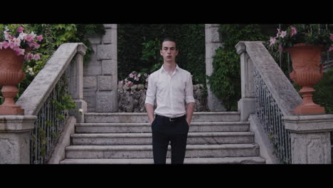 man in a formal outfit on a villa steps