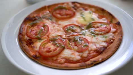 pizza margherita en un plato blanco con luz de ventana suave brillando