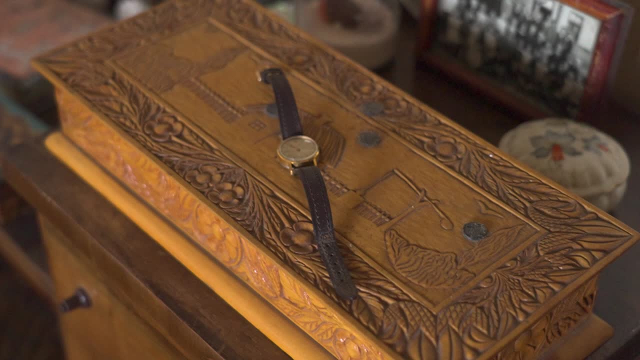 Carved wooden box with wristwatch placed on top