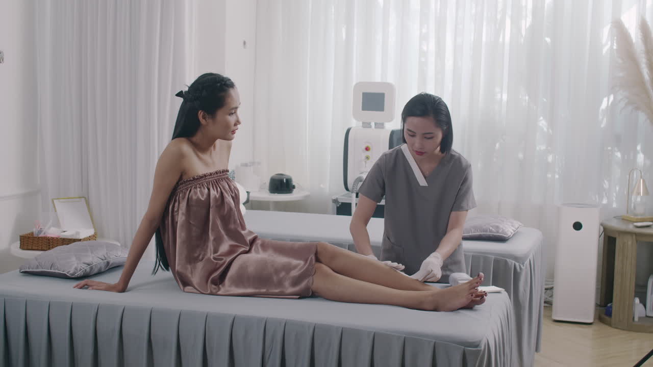 Young Female Client Visiting Spa Salon during Depilation Procedure