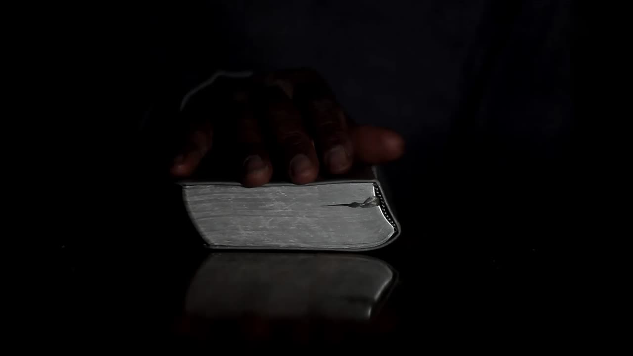 молящийся богу с руками вместе с библией и крестом карибский мужчина молящийся на черном фоне стоковое видео