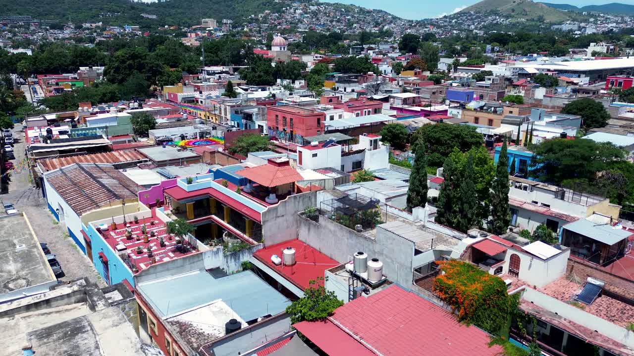 Drone aerial landscape of colourful commercial buildings busy streets apartment unit blocks housing in Oaxaca city old town square Mexico downtown community travel
