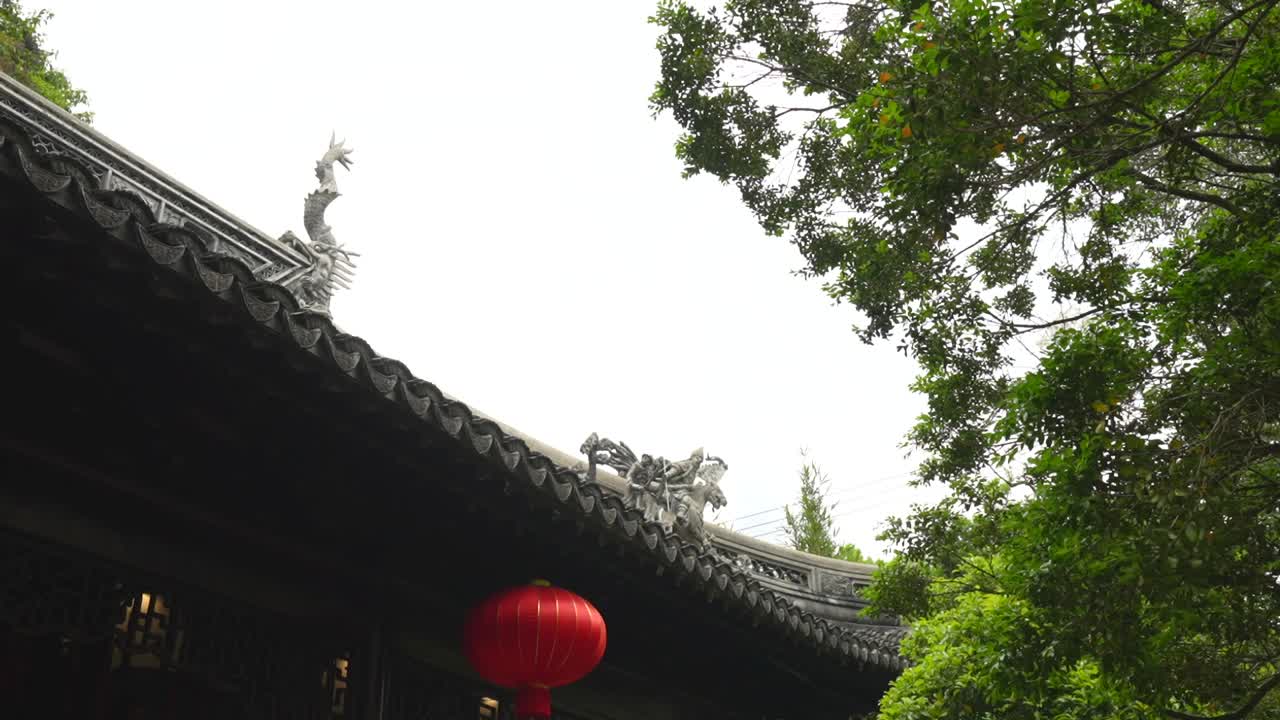 Red lantern hanging from a balcony and roof figures at Yuyuan Garden in Shanghai, China