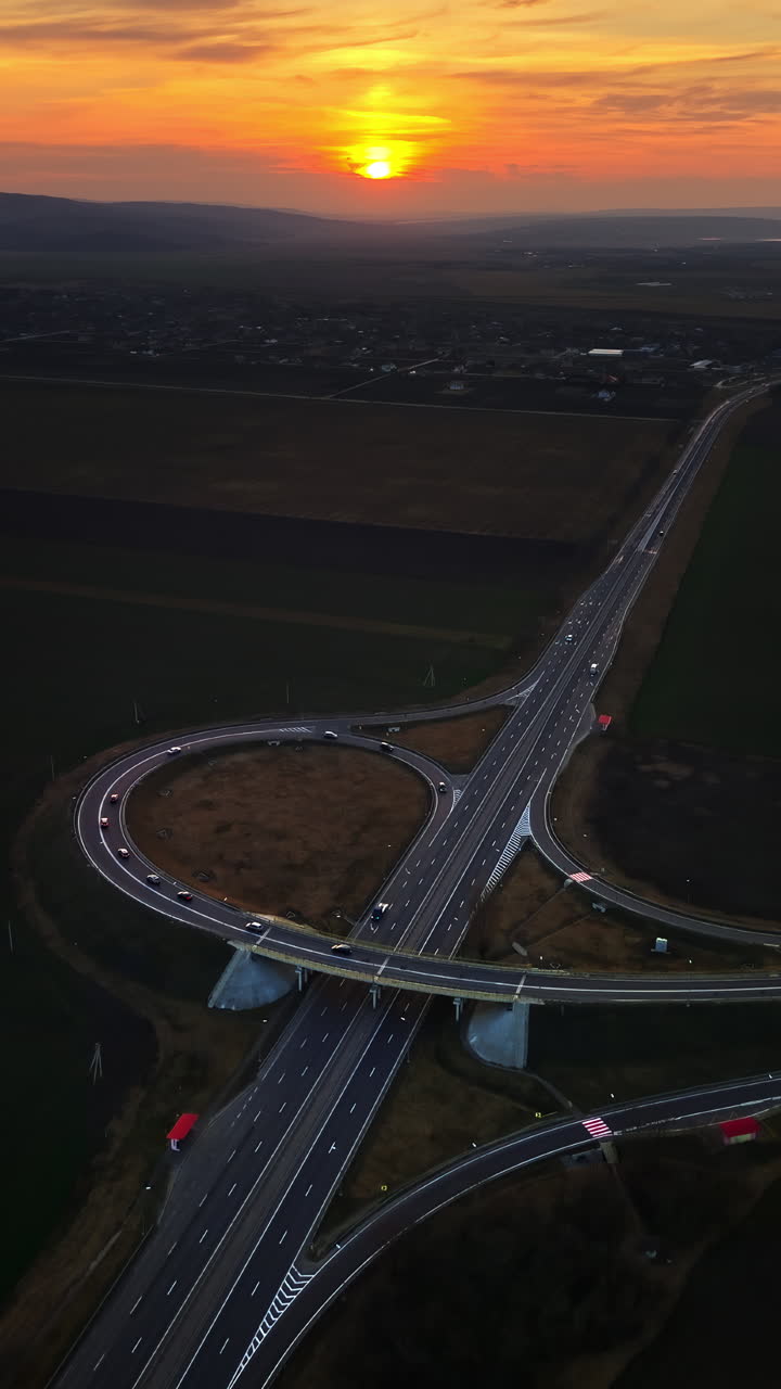 Aerial drone view of cars driving on the highway in Moldova at sunset. Vertical