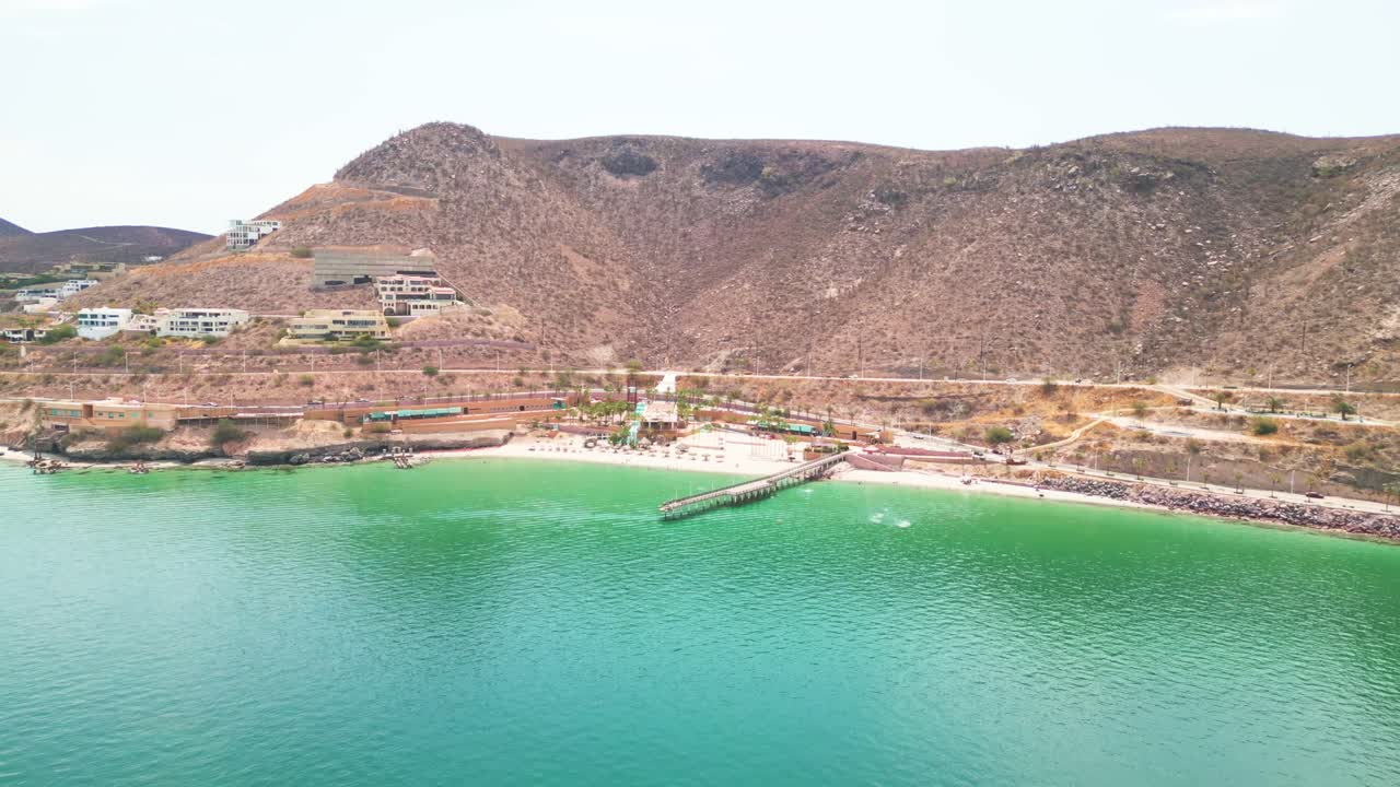 Aerial shot of Coromuel Beach in La Paz, showing turquoise water and surrounding hills