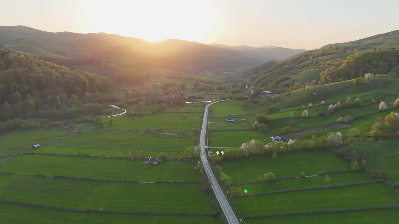 Aerial view of rural road and hills in evening near Manastirea Humorului village