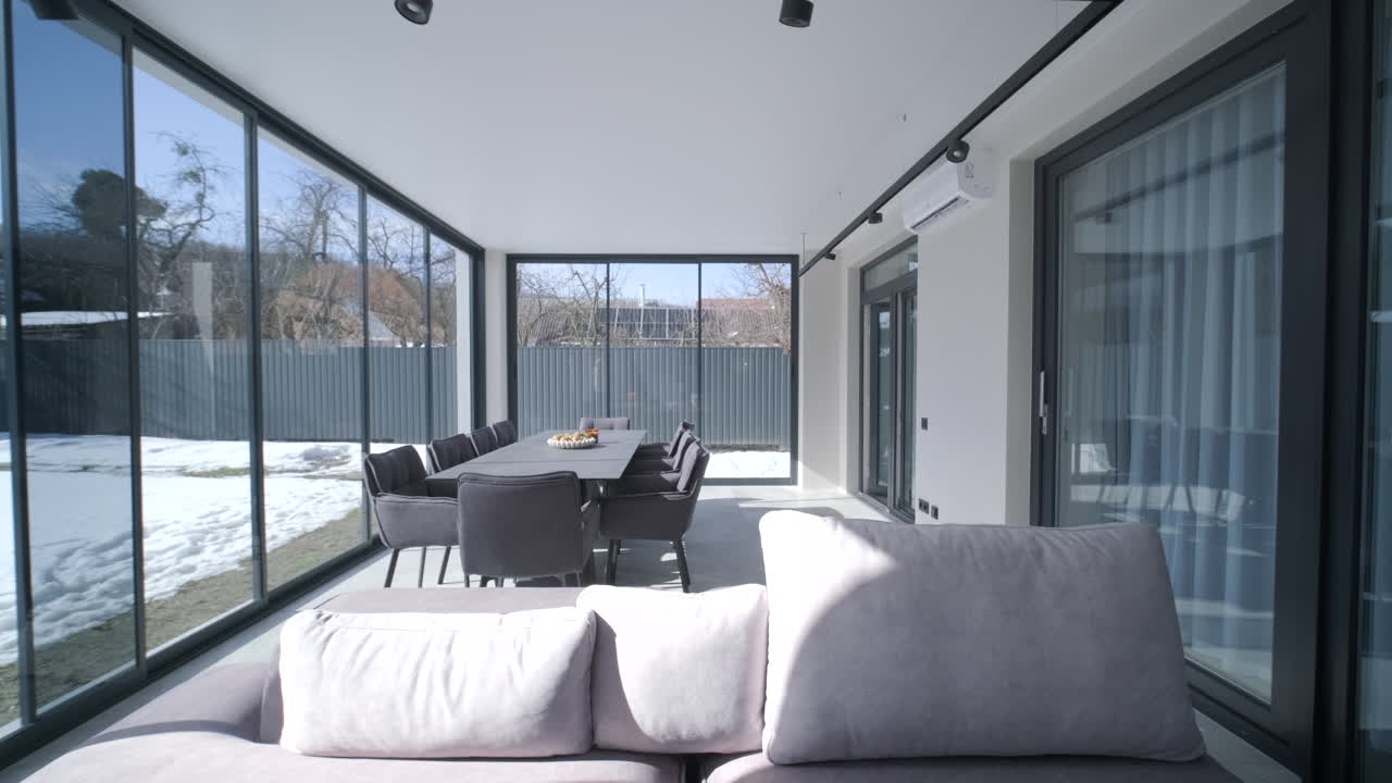 Interno spazioso di veranda moderna con tavolo da pranzo e vista innevata
