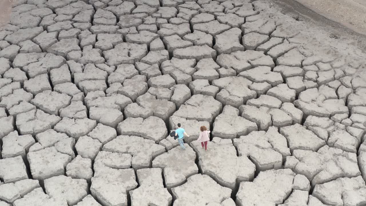 gente caminando por la tierra agrietada